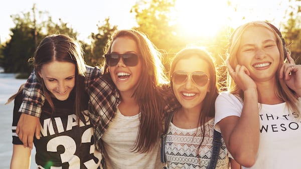 Teenage girls laughing and walking on a line